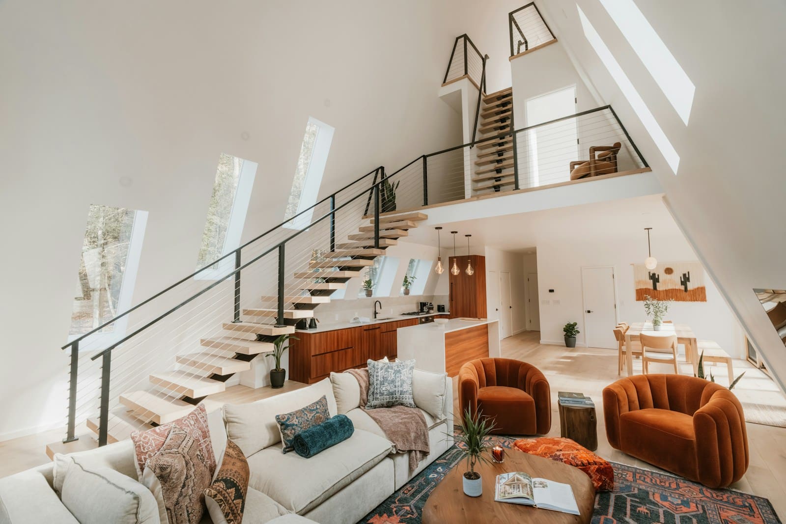 Modern a-frame living room with open loft and kitchen.